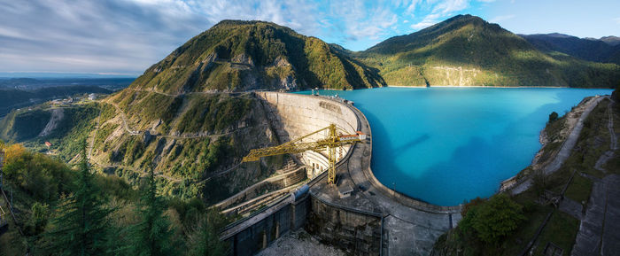 Panoramic view of hydroelectric dam and mountain range against sky