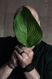 Close-up of man holding leaf