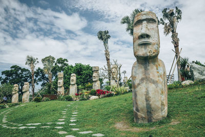 Statue against trees and plants against sky