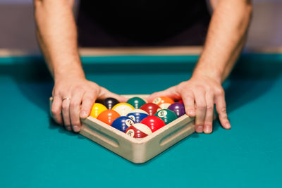 Midsection of man playing pool