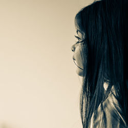 Side view of young woman against white background