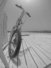 Wheel on beach against clear sky