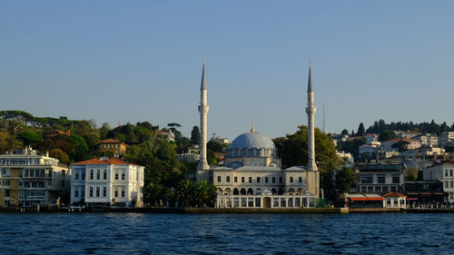 Buildings in city against clear sky