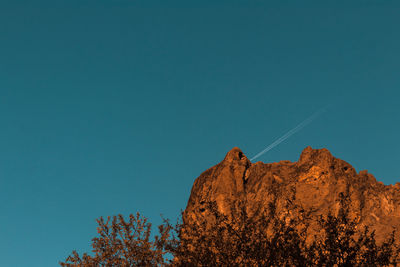 Low angle view of rock formation against clear blue sky