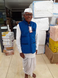 Portrait of smiling senior man against boxes in warehouse