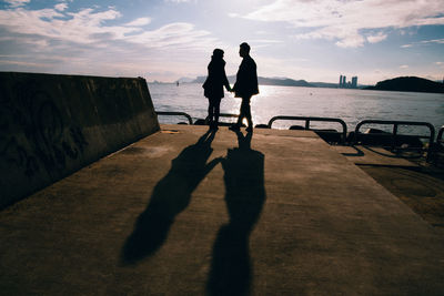 Shadow of man and woman on road