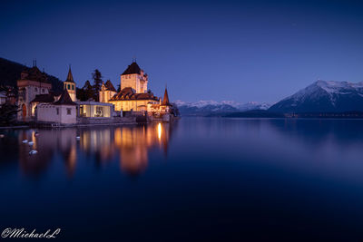 Reflection of buildings in lake at dusk