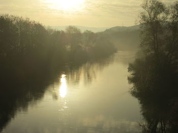 Scenic view of lake against sky at sunset