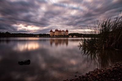 Reflection of buildings in lake at sunset