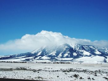 Scenic view of snowcapped mountains against blue sky