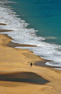 Aerial view of man walking on beach