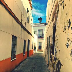 Alley amidst buildings in city against sky