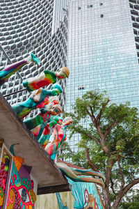 Low angle view of multi colored umbrellas hanging on building