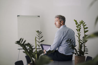 Businessman using laptop while sitting on table at office