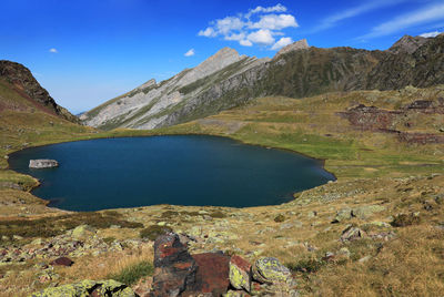 Scenic view of lake and mountains against blue sky