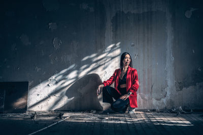 Portrait of young man sitting on wall