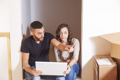 Portrait of young woman using digital tablet while sitting at home