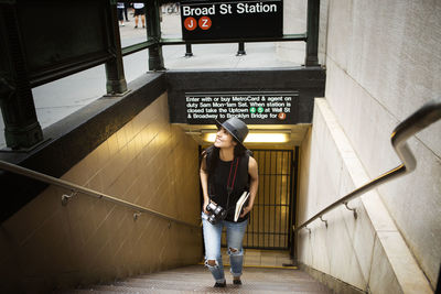 High angle view of woman with camera walking on steps