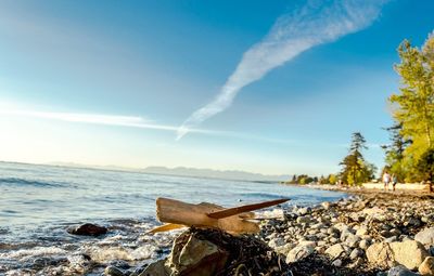 Scenic view of crescent beach against sky on sunny day