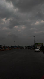 View of city street against cloudy sky