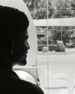 Smiling young man looking through window