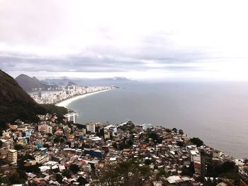 Aerial view of town by sea against sky