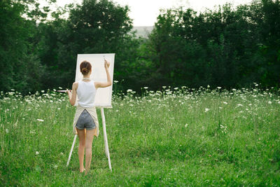 Rear view of woman standing on field