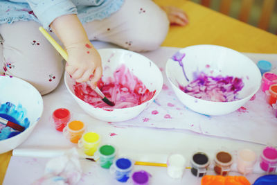 High angle view of child hand painting 