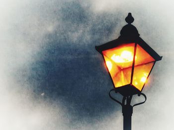 Low angle view of illuminated street light against sky