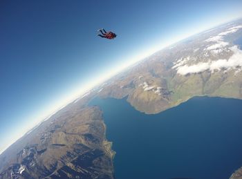 Person sky diving over mountains against