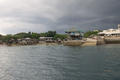 Houses by sea against sky