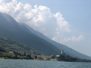 Scenic view of sea by mountains against sky