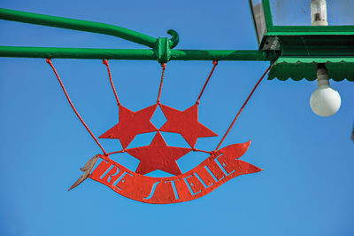 Low angle view of decoration hanging against blue sky