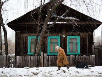 VIEW OF A SNOW COVERED HOUSE AGAINST BUILDING