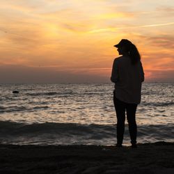 Full length of man standing on beach during sunset