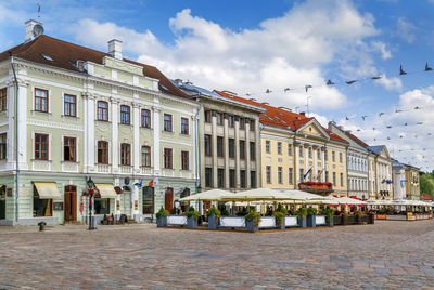 Buildings in city against cloudy sky