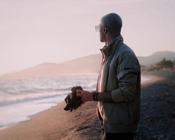 Rear view of man standing at beach