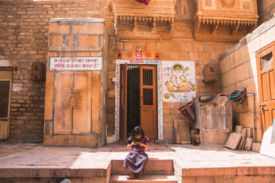 Full length of senior man sitting outside building