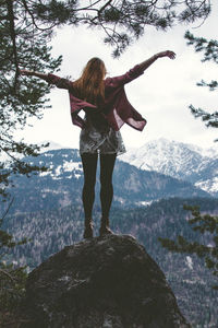 Rear view of woman standing on rock