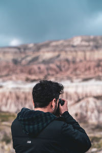 Man photographing against sky