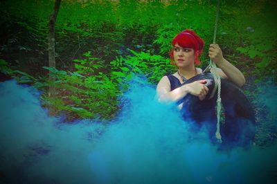 Full length of young woman holding red tree