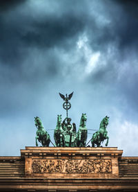 Low angle view of brandenburg gate against cloudy sky