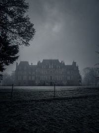 Buildings by river against sky