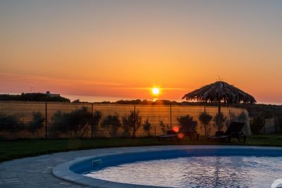 View of swimming pool at sunset