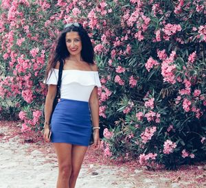 Portrait of a beautiful young woman standing against plants