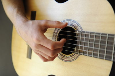 Midsection of man playing guitar