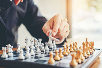 Midsection of man playing with chess