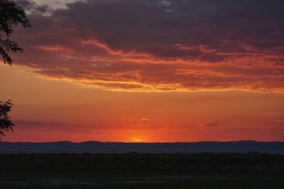 Scenic view of silhouette landscape against orange sky