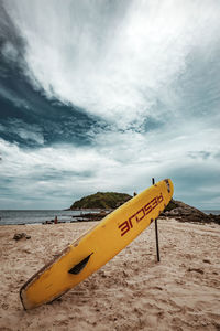 Information sign on beach against sky