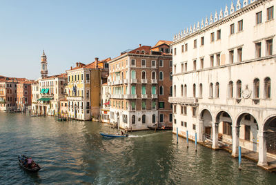 Canal by buildings in city